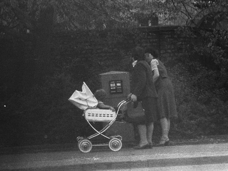 Stasi-Observation von Bürgern beim Einwurf von Post in einen öffentlichen Briefkasten. Hier stehen zwei Frauen am Briefkasten, eine davon mit Kinderwagen.