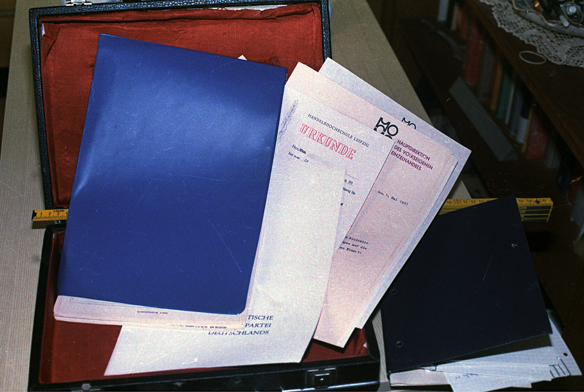 Bild eines aufgeklappten Koffers mit verschiedenen privaten Dokumenten