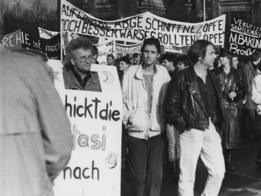 Blick in einen Demonstrationszug: Die Demonstranten tragen beschriftete Transparente.