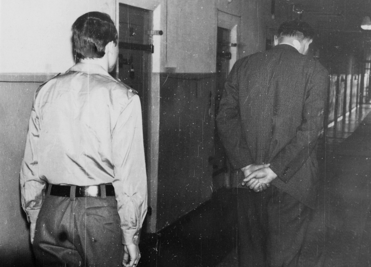 Ein Häftling geht durch den Zellengang. Ein Wärter begleitet ihn. Fotodokumentation der Stasi über Einrichtung und Sicherungsmaßnahmen in Haftanstalten aus dem Jahr 1967.